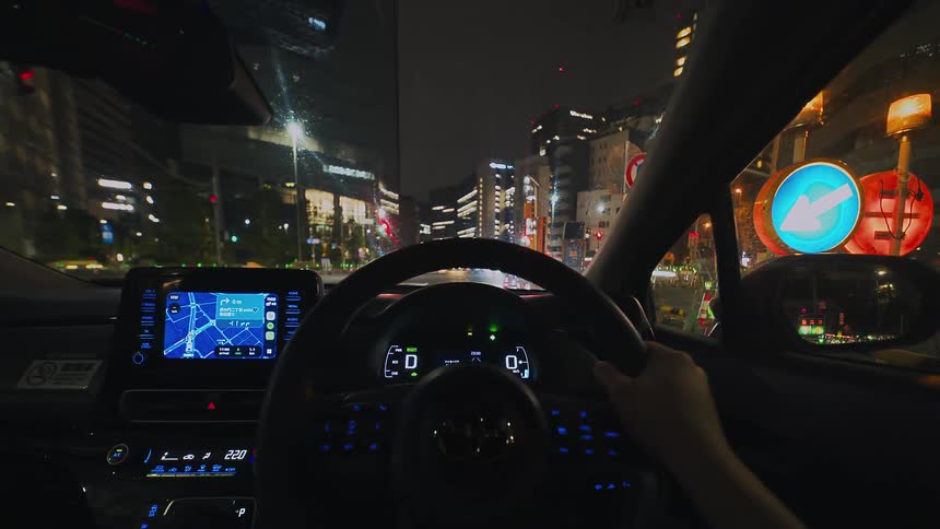 A fast-paced first-person perspective hyperlapse of driving through the streets of Tokyo at night, capturing the vibrant city lights