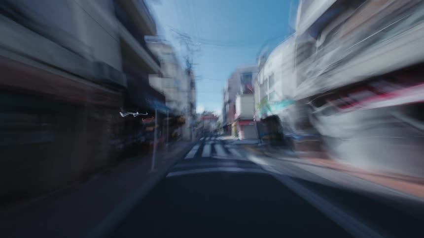 A surreal first-person hyperlapse perspective speeds through the motion-blurred streets of urban Japan