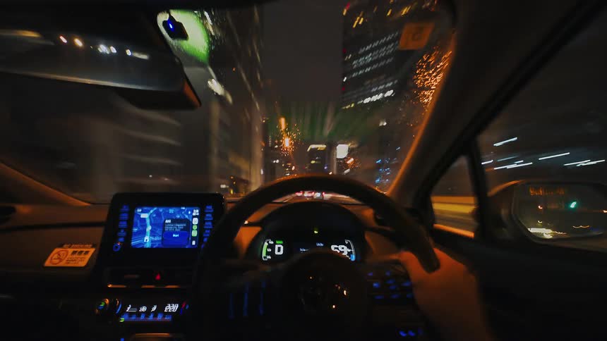 A dynamic point-of-view timelapse of driving a car through a well-lit tunnel and onto a rainy city highway at night