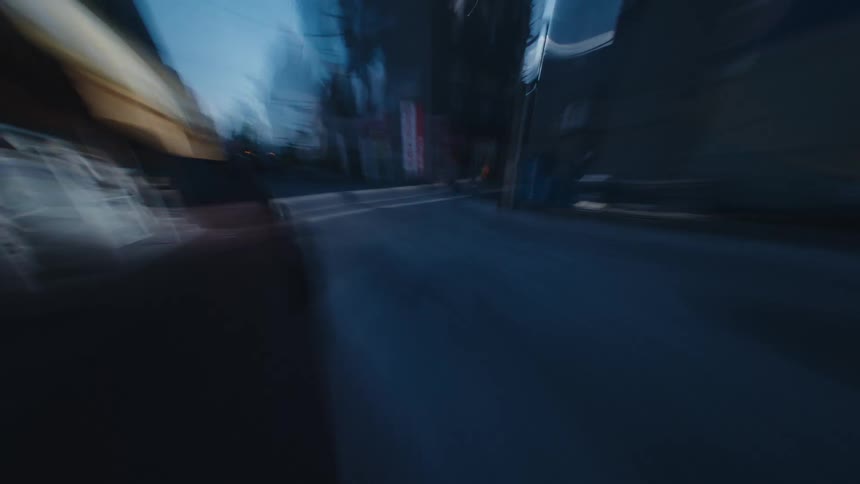 A dreamlike first-person hyperlapse speeds through the motion-blurred streets and alleys of a bustling city during the day
