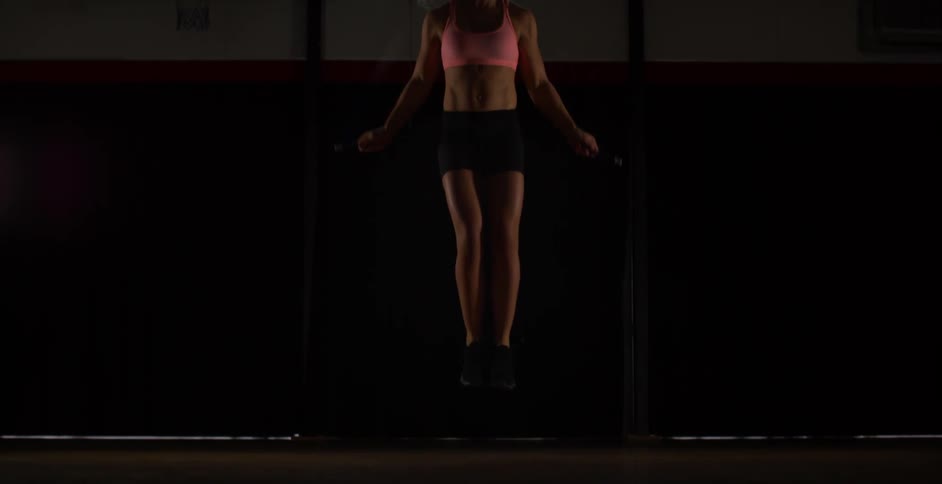 A woman is jumping rope in the gym