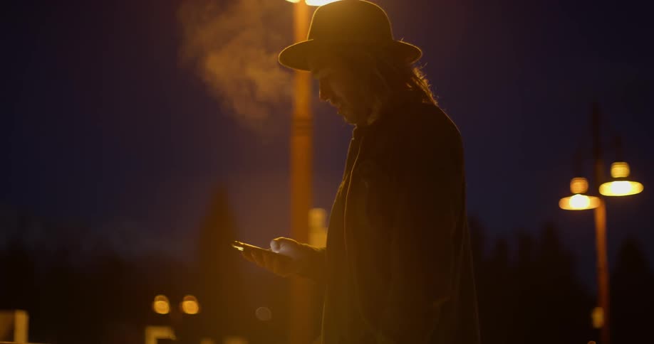 A man is standing outside using his phone