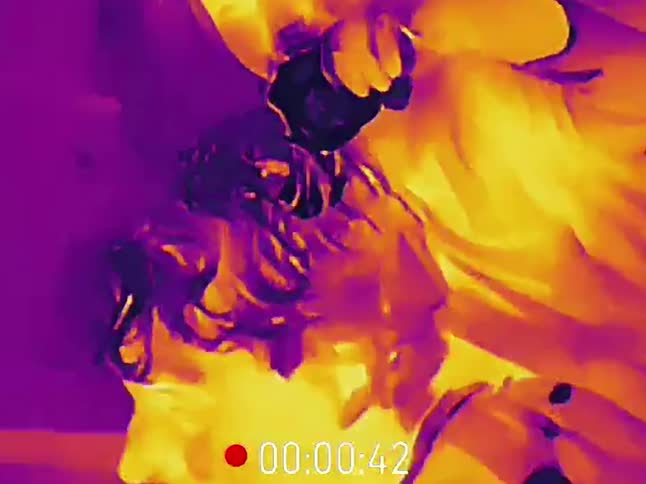Infrared thermal vision footage captures a father and his young child singing together while the child sits on his shoulders