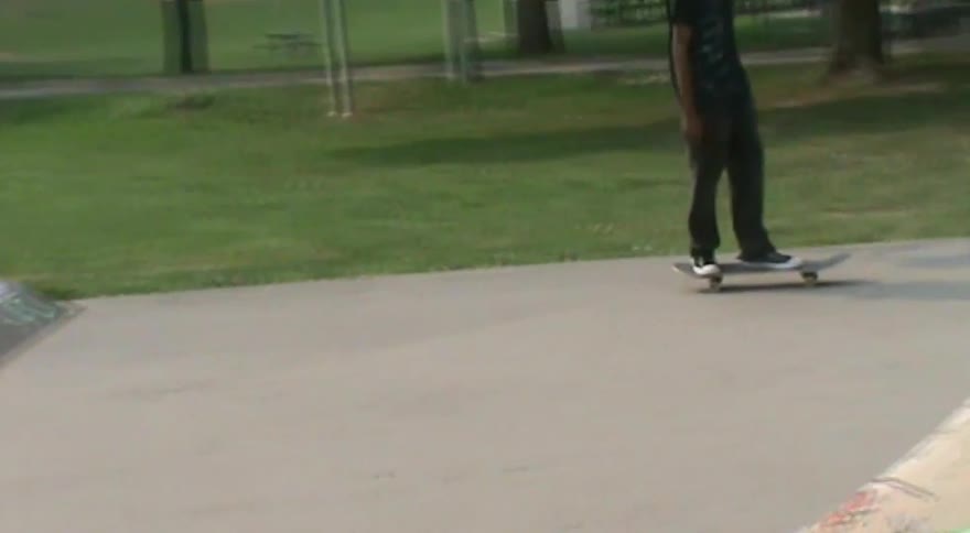 A skateboarder cruises around a graffiti-covered skate park in a stylized video with a motion blur effect