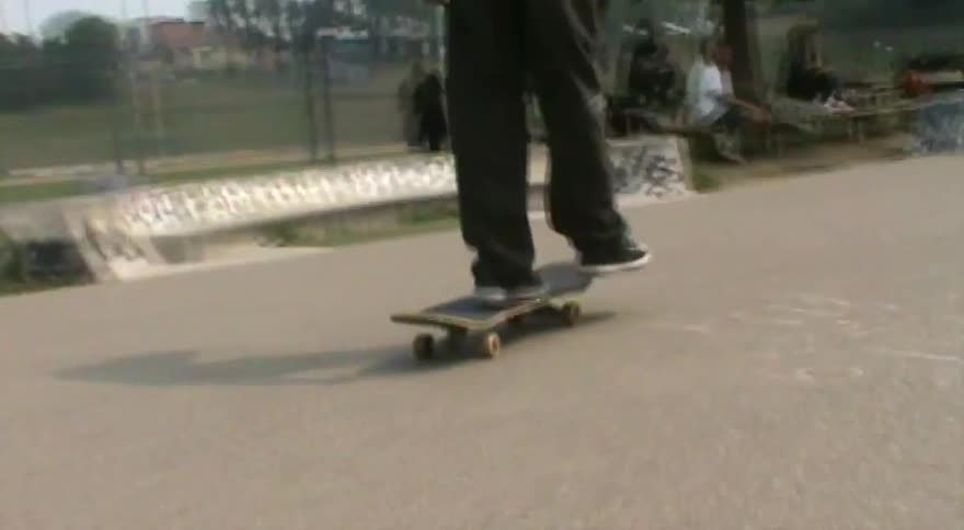 A skateboarder performs tricks at an outdoor skatepark in dreamy, vintage-style footage