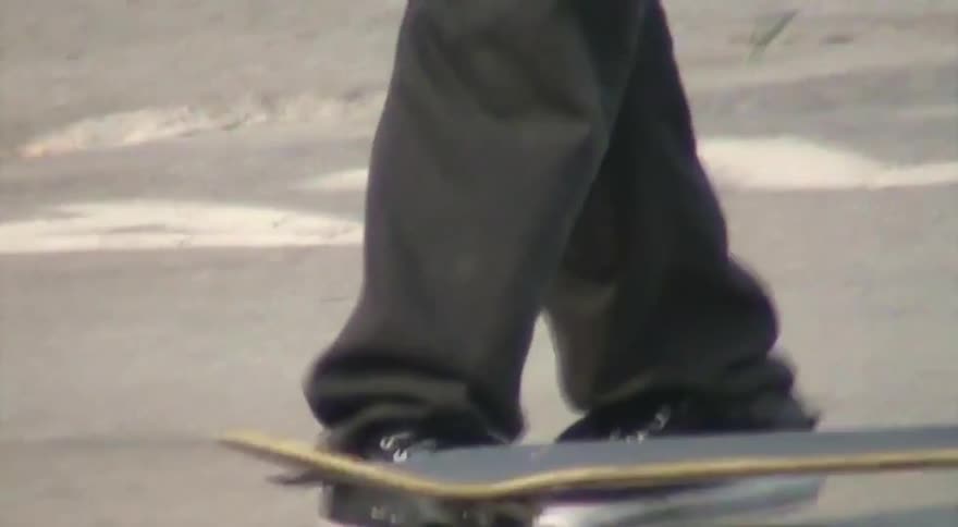 A gritty, vintage-style close-up of a person's feet stepping on and flipping up a skateboard in a concrete skate park