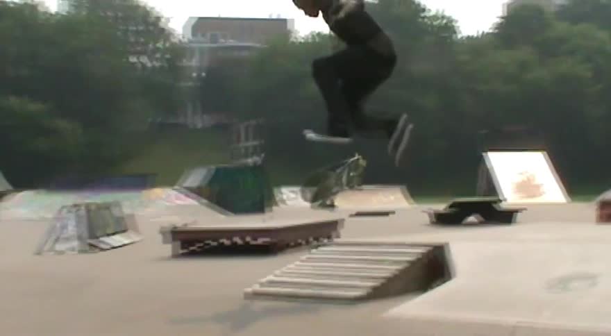 Slow motion footage captures a young man performing a series of skateboarding tricks at an outdoor skatepark
