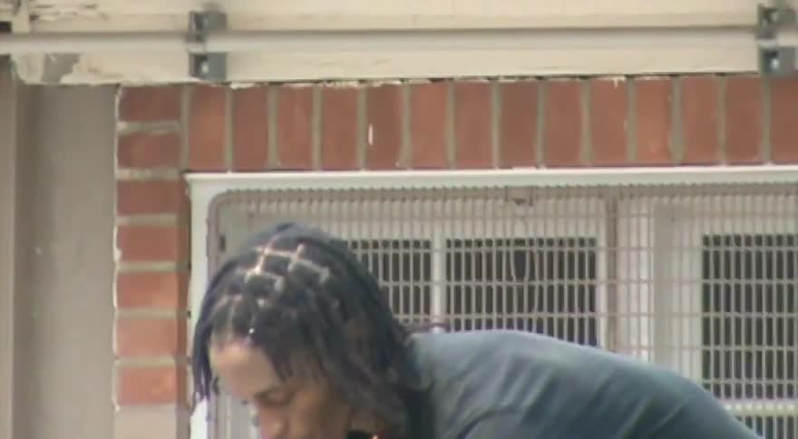 A young man with braids hydrates with a water bottle before hopping on his skateboard and riding away at a skatepark