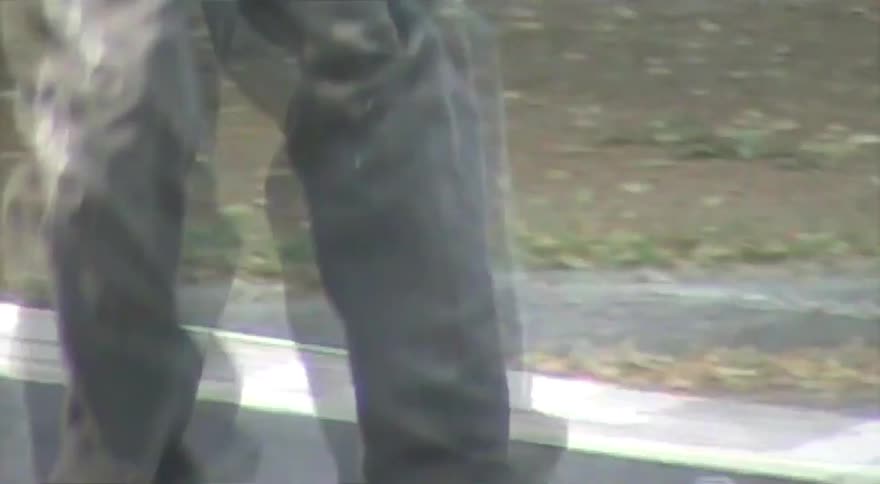 Lo-fi, vintage-style footage of a young man with dreadlocks skateboarding in an urban park