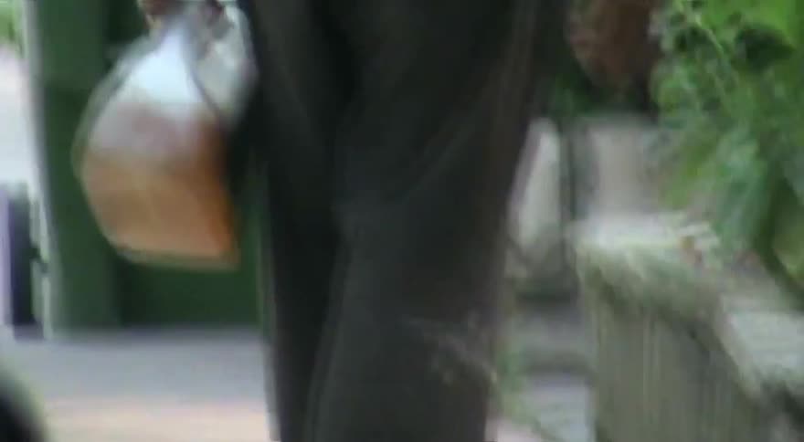 A young person with a bright orange backpack skateboards down a city sidewalk carrying a jug in this lo-fi vintage-style video