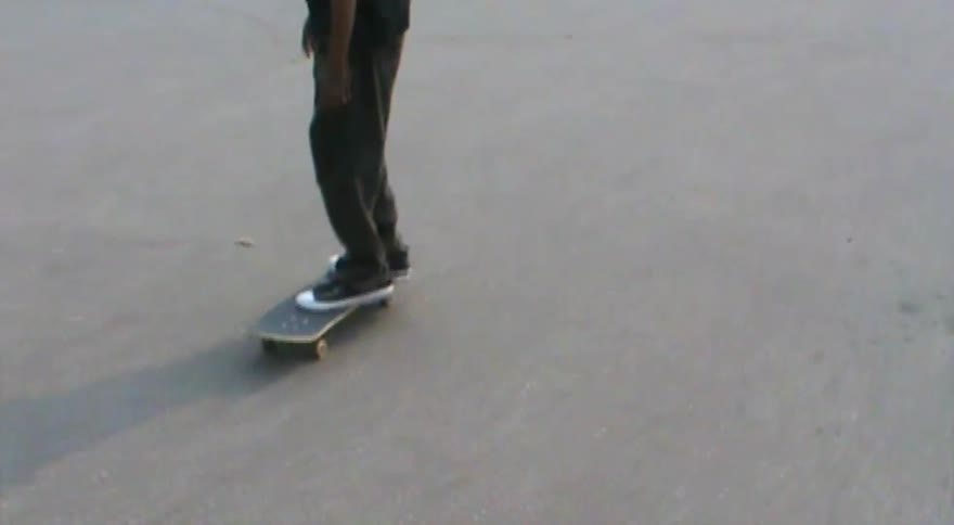 Slow-motion close-up of a person's feet as they attempt a kickflip on a skateboard and fail to land it