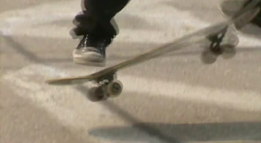 Close-up of a person skateboarding and doing a trick on the pavement
