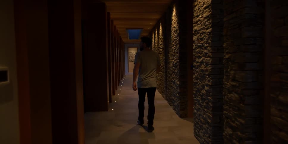 A man is walking down a long hall