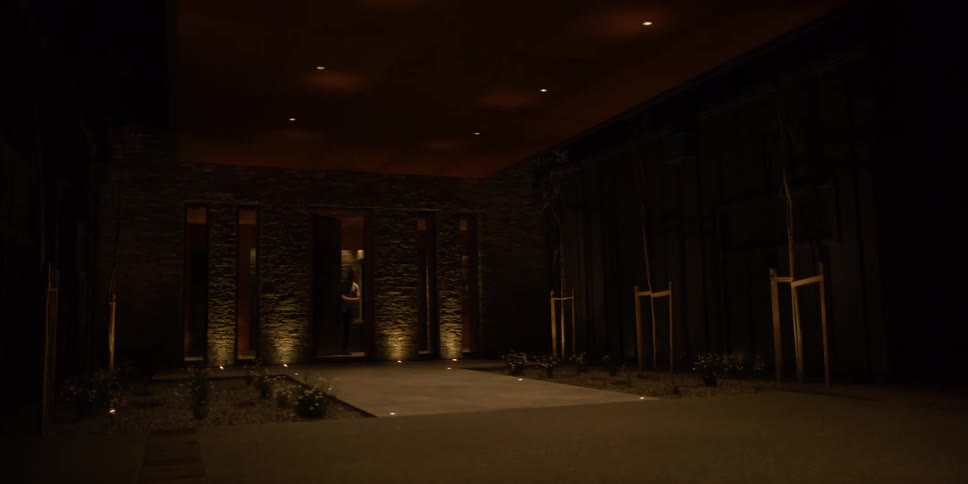 A man enters a door and closes it at night