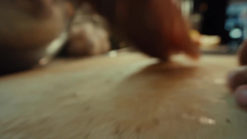 Close-up slow-motion shot of a chef's hands cleaning and seasoning a whole fish on a cutting board