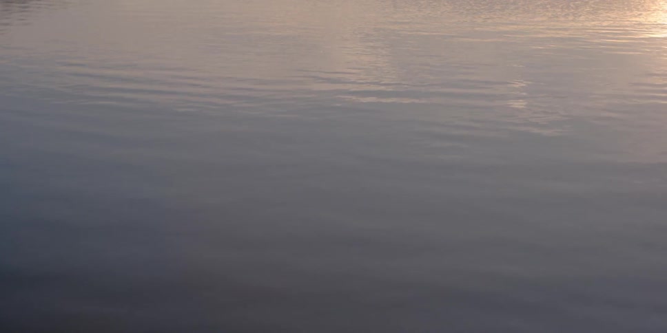 The water is calm and reflects the sun
