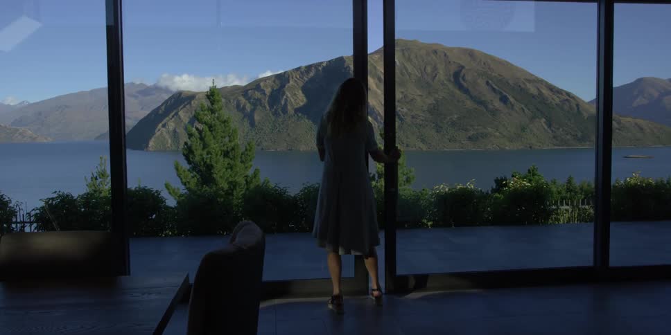 A woman looks out her window at the mountain ahead
