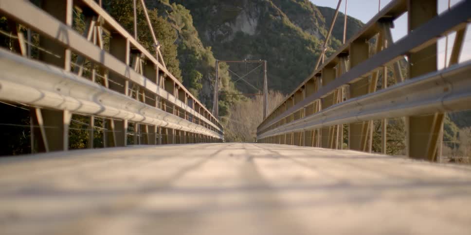 A wooden bridge leading to a mountainous area