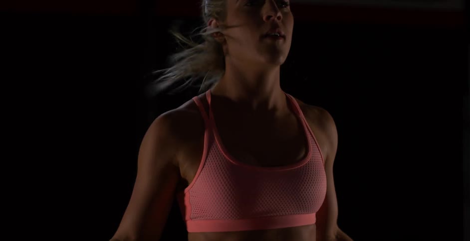 Woman jumps up and down in a dark room