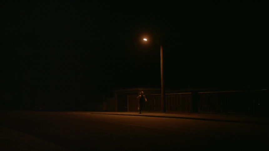 A woman runs under a single lamp post