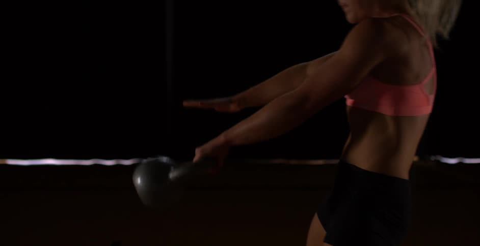 A woman exercises using a kettlebell