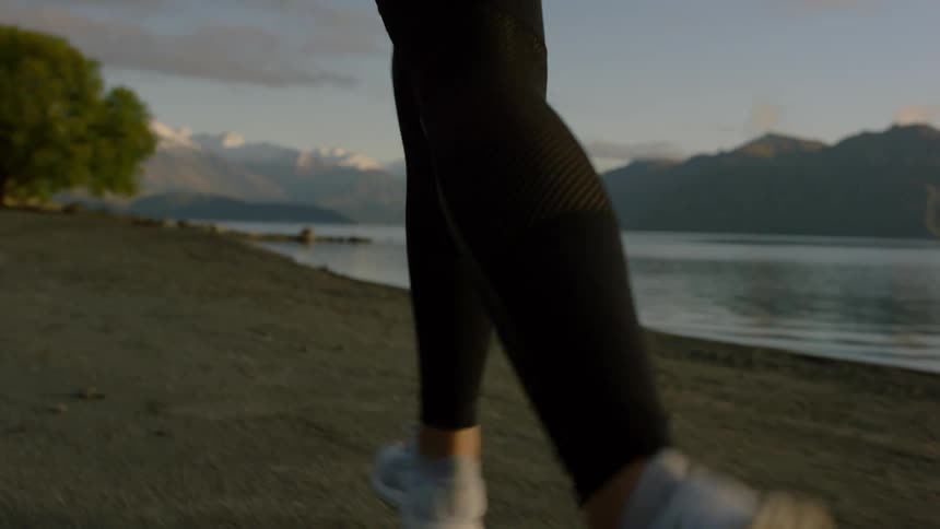 A woman is running on the sand by the water