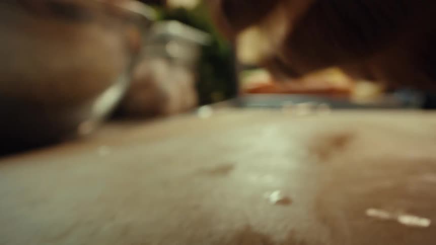 An extreme close-up macro shot of a chef meticulously cleaning a raw fish on a cutting board