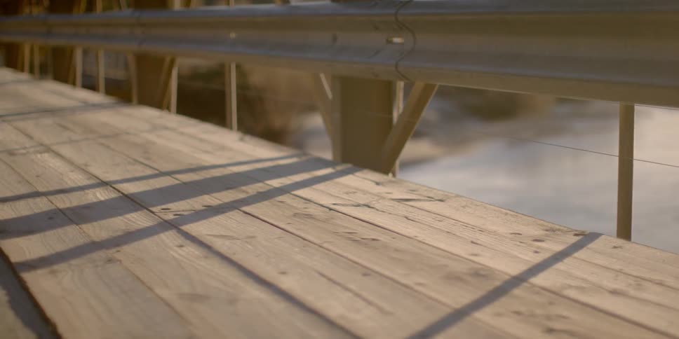A railing lines a wooden bridge