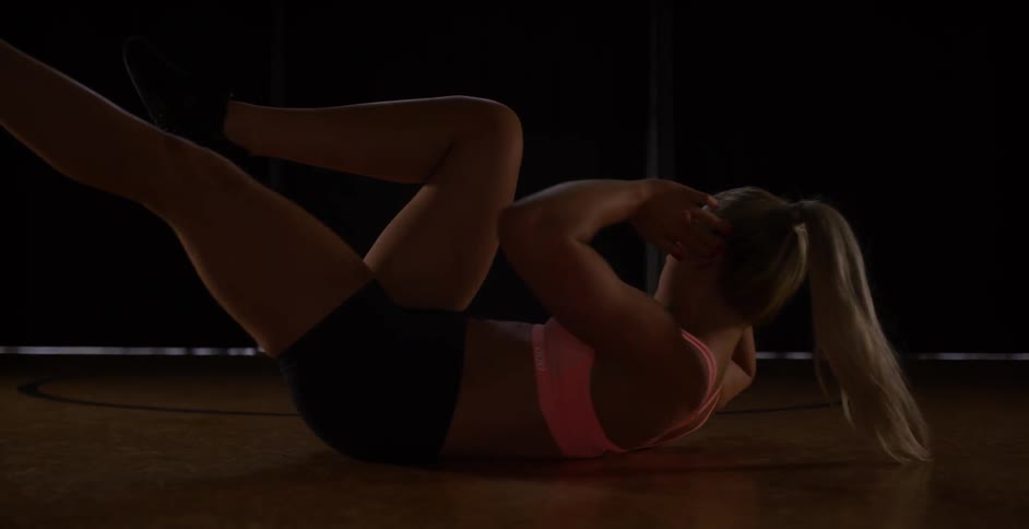 A woman is on the ground exercises