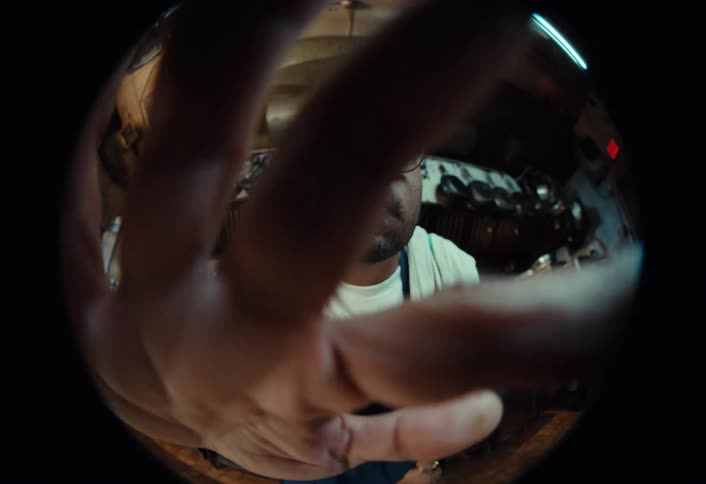 Fisheye point-of-view shot of a chef in a restaurant kitchen who slowly approaches the camera and threatens it with a large knife