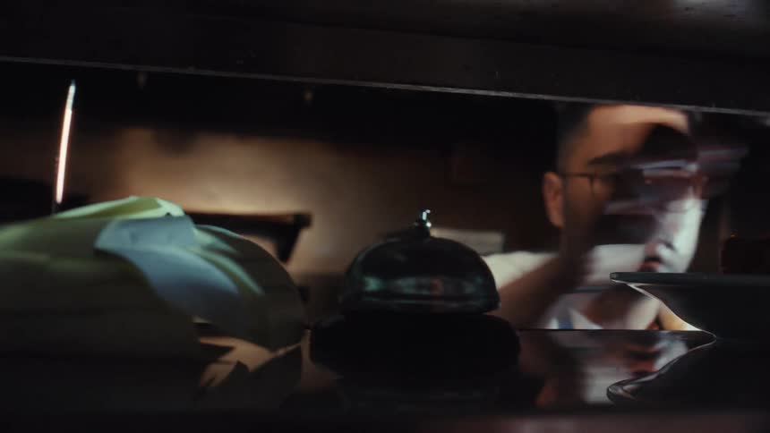 Focused chef in a restaurant kitchen places a finished dish on the pass and rings the service bell to signal an order is up