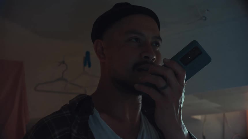 Close-up of a serious man having an intense conversation on his smartphone in a dark room