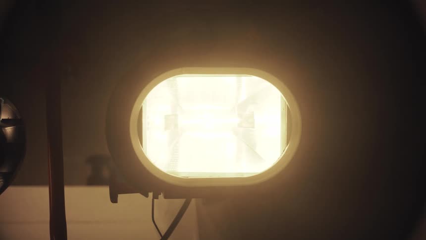The bright filament of a powerful halogen lamp slowly fades to black before flickering back to life