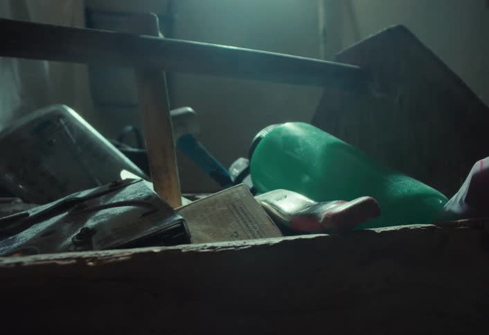 A quick whip pan reveals a dusty, junk-filled shelf in a dark and creepy basement