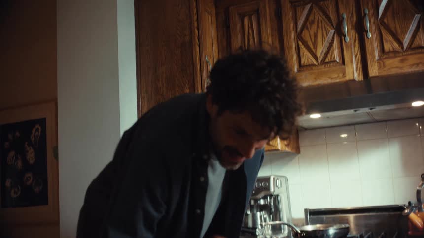 A playful father and his young child share a sweet moment in the kitchen as she puts red putty on his nose