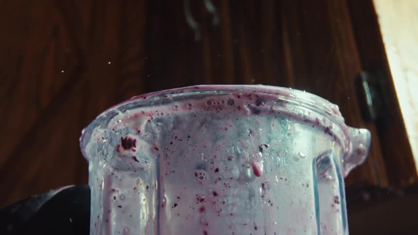 A powerful blender overheats, causing steam to rise as a purple smoothie splashes out in dramatic slow motion