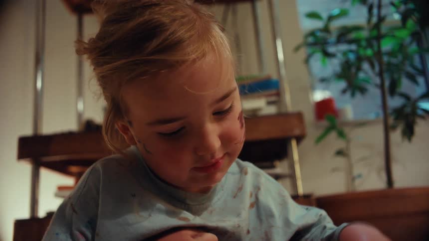 Young child plays with toy cars in spilled potting soil on the indoor floor