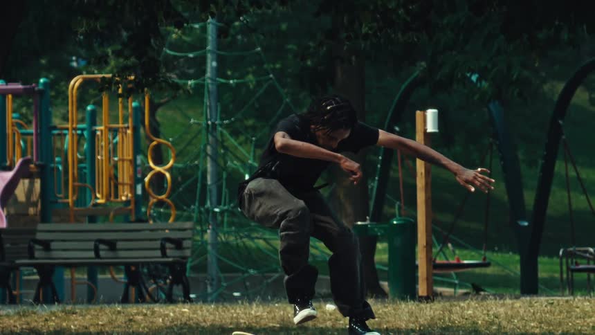 Skateboarder executes a primo slide down a rail at a park in cinematic slow motion