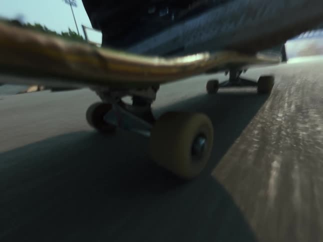 An action-packed, point-of-view shot from a skateboard as it rides around a skatepark and up ramps