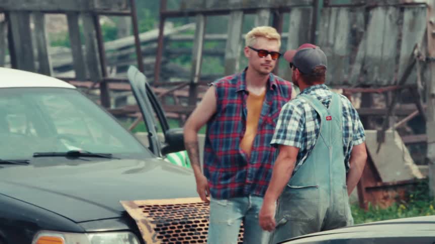 Two men face off between their demolition derby cars in a rural junkyard before running back to their vehicles
