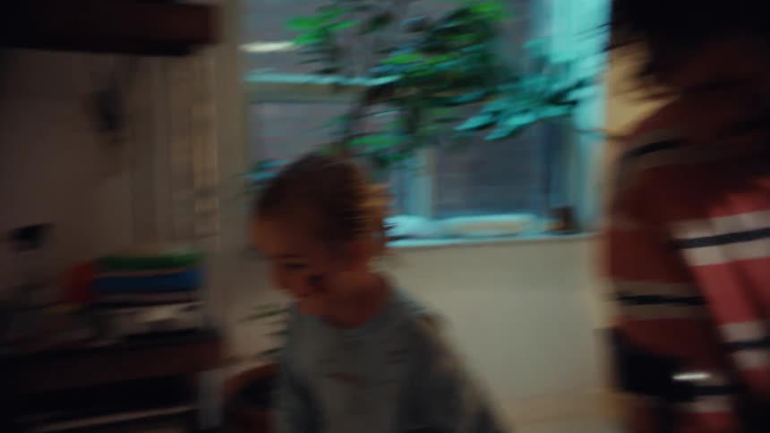 A playful moment between a father and daughter is juxtaposed with a disturbing shot of what appears to be blood on the floor