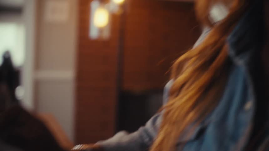 A close-up shot of a woman's hands typing on a computer keyboard transitions to a profile view of her smiling face as she works in a warmly lit home office