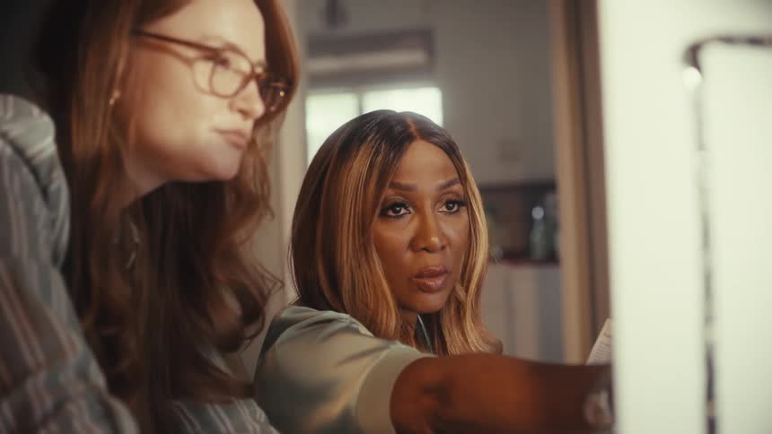A close-up of two diverse female colleagues collaborating and analyzing data on a computer in an office