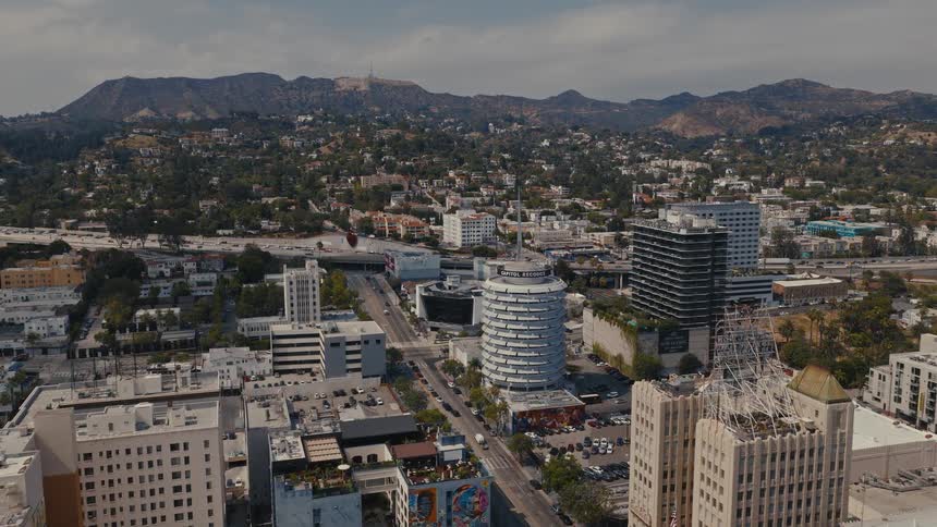 A daytime aerial timelapse of Hollywood, featuring the iconic Capitol Records Building and the Hollywood sign in the distant hills