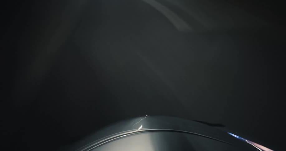 A hypnotic time-lapse from a car's hood captures the abstract light trails and patterns of a high-speed drive through a city tunnel at night