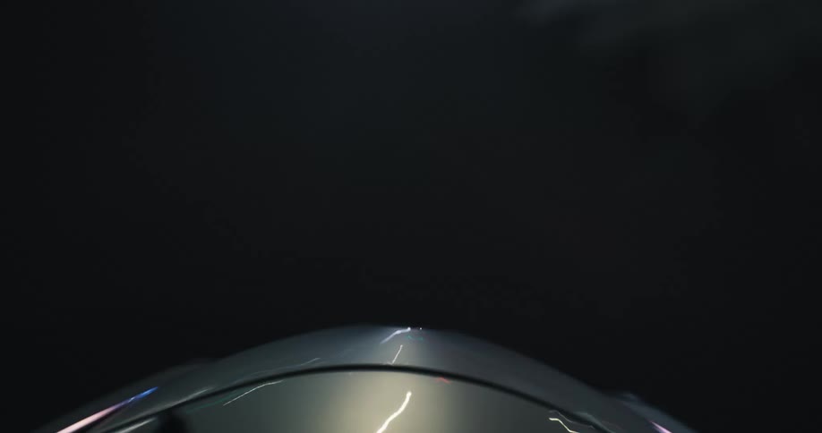 A hypnotic point-of-view time-lapse captures streaks of light from the hood of a car speeding through a city at night