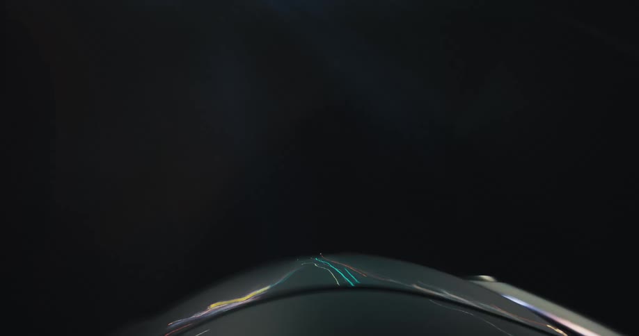 An abstract first-person view from a car's hood shows a dizzying time-lapse of driving at night