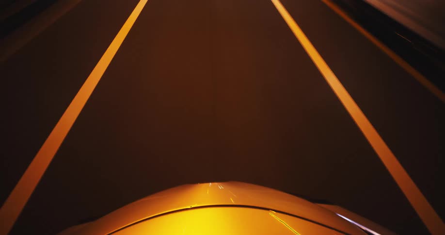 A hypnotic time-lapse from a car's hood captures the blur of city lights and road lines during a high-speed night drive