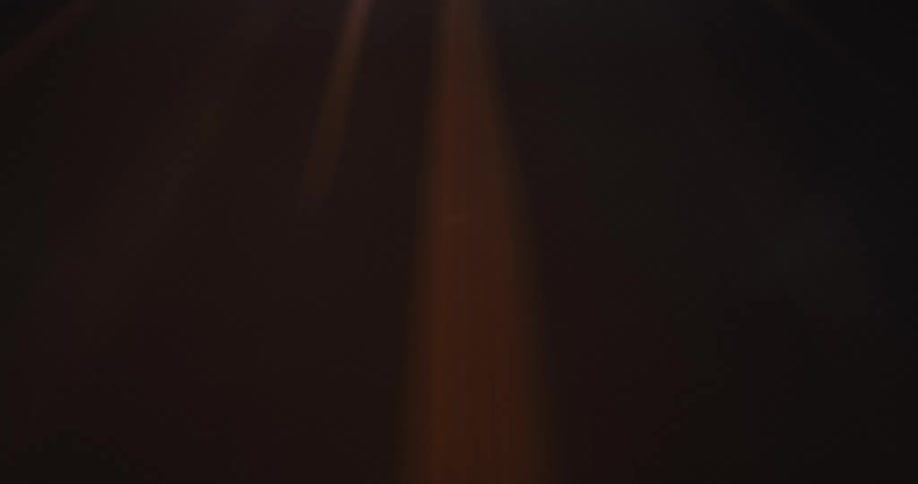 A fast-paced, abstract time-lapse of driving down a highway at night, with lights blurring into streaks of color