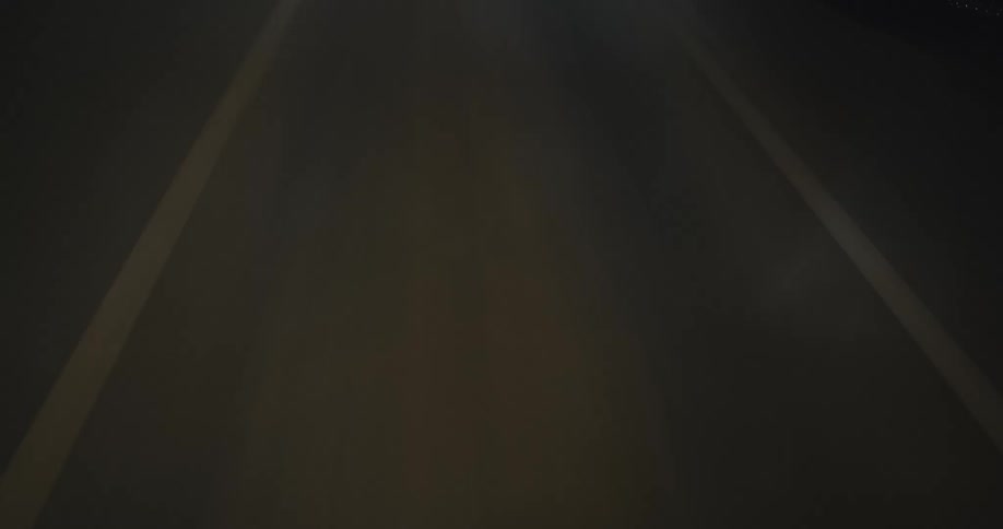 A seamless loop of a high-speed journey down a stylized, abstract highway at night